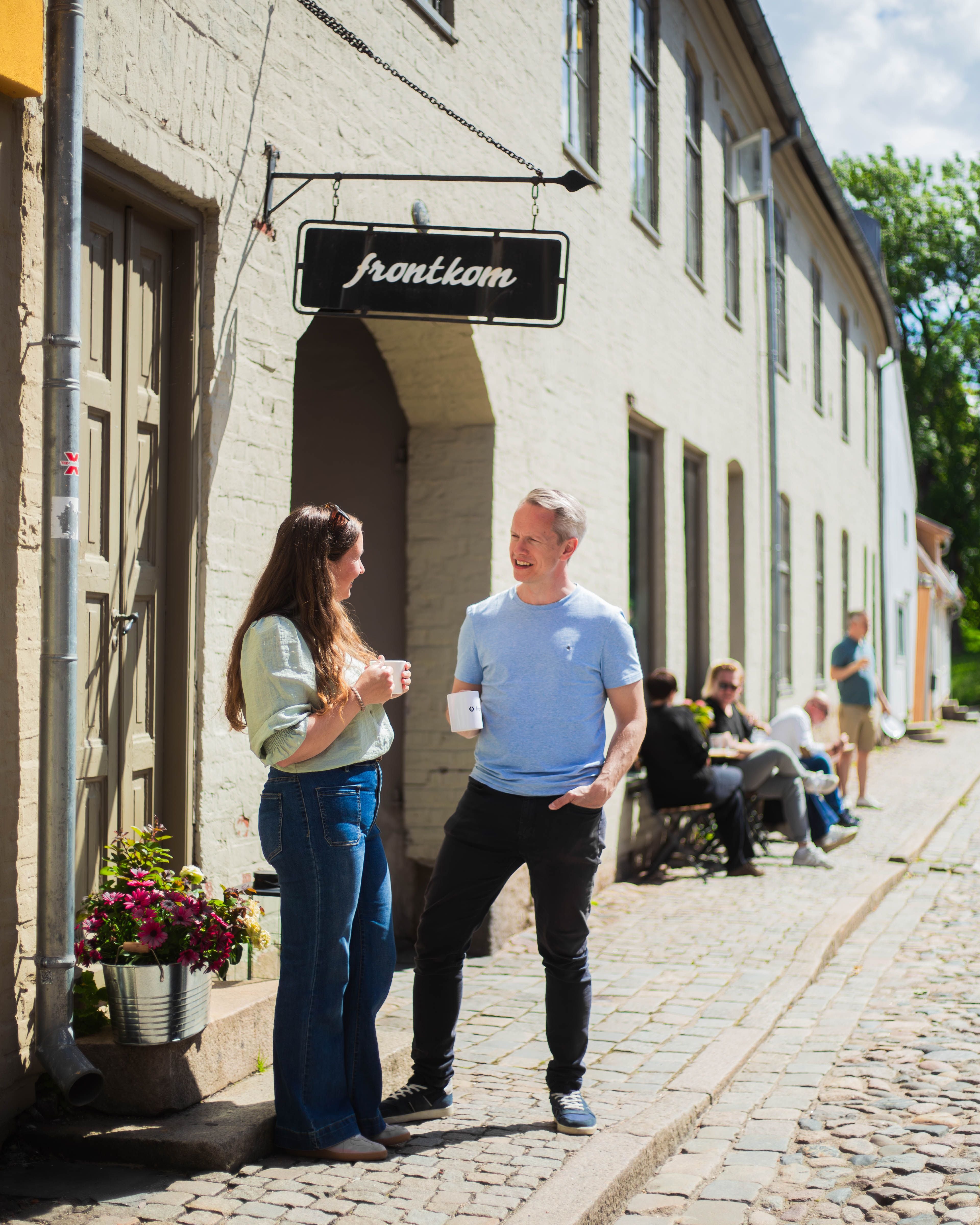 To kolleger foran en gul husvegg i Gamlebyen