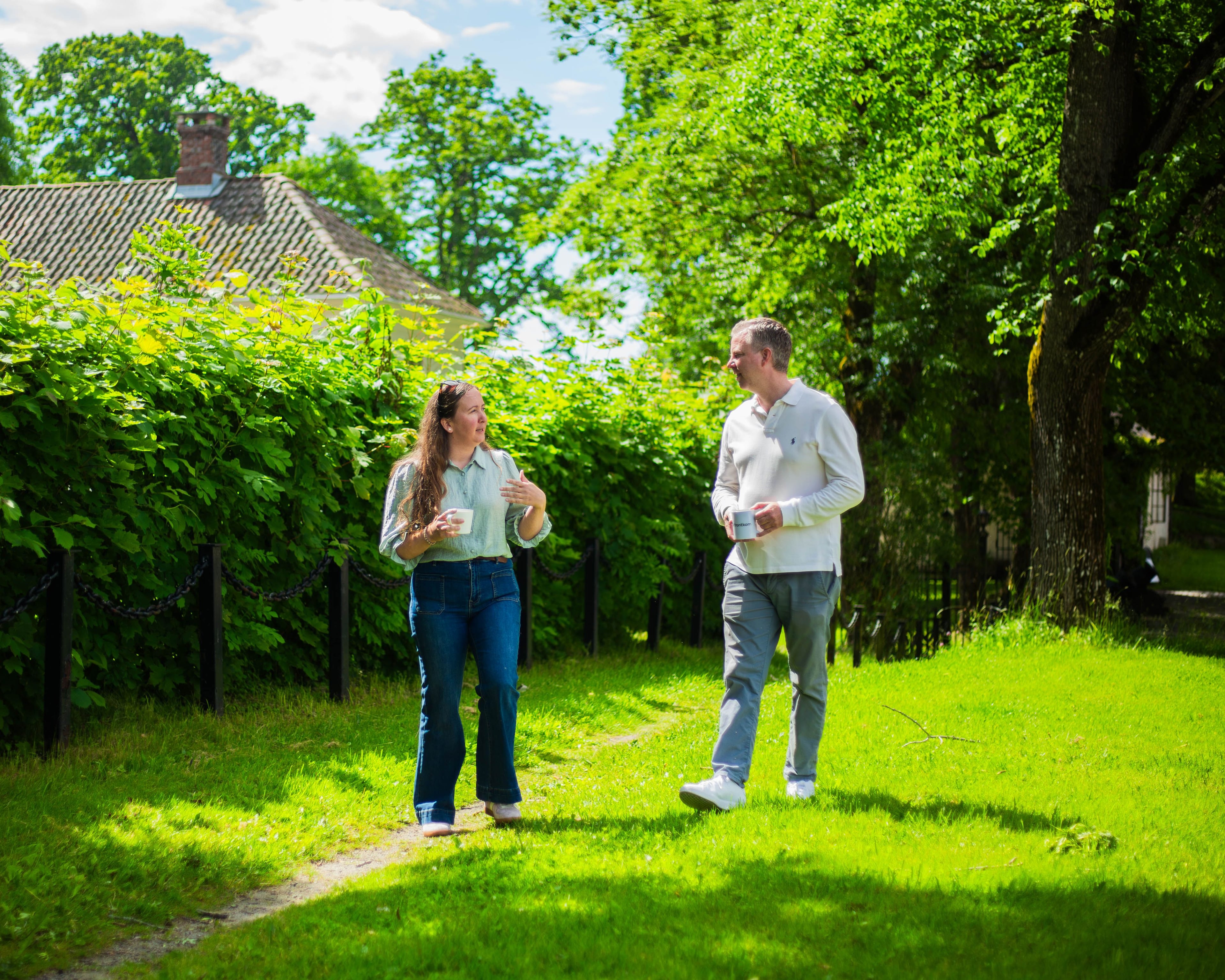 To kolleger som ler og spøker på gressplenen